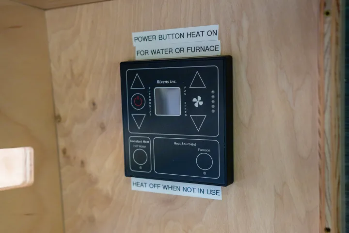 This RV rental's heating control panel shows thermostat, fan speed, hot water, and furnace settings with operational instructions.. RAM ProMaster 2022