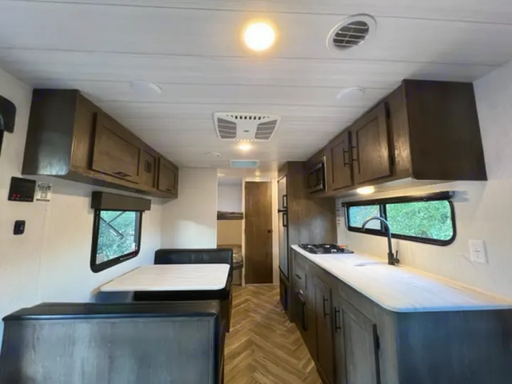 Spacious RV rental interior featuring a full kitchen with stovetop & sink, and a comfortable dinette. Perfect for adventure!. Forest River EVO Select 268 BH 2022