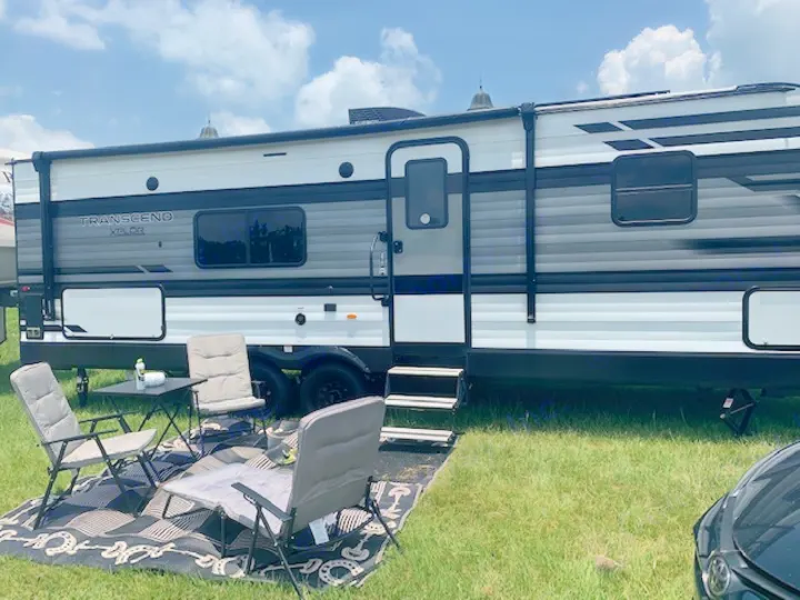 Perfect RV rental setup! A Transcend Xplor travel trailer with an awning, chairs, and table for outdoor comfort.. Grand Design Transcend Xplor 2022