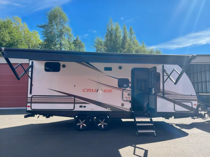 This RV rental travel trailer with its awning out is ready for outdoor adventures under a blue sky.. Crossroads RV Cruiser Aire 2022