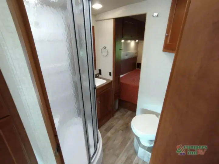 Spacious RV rental interior with a full bathroom (shower, toilet, sink) and a peek into the cozy bedroom.. Winnebago Vista 2017