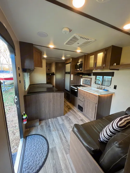 Modern RV rental interior featuring kitchen, dinette, bunk beds, and living space.. Keystone RV Hideout LHS 2020
