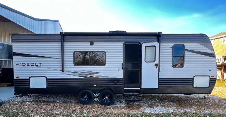 Side view of a modern Hideout by Keystone travel trailer. Perfect for your next rv rental getaway.. Keystone RV Hideout LHS 2020
