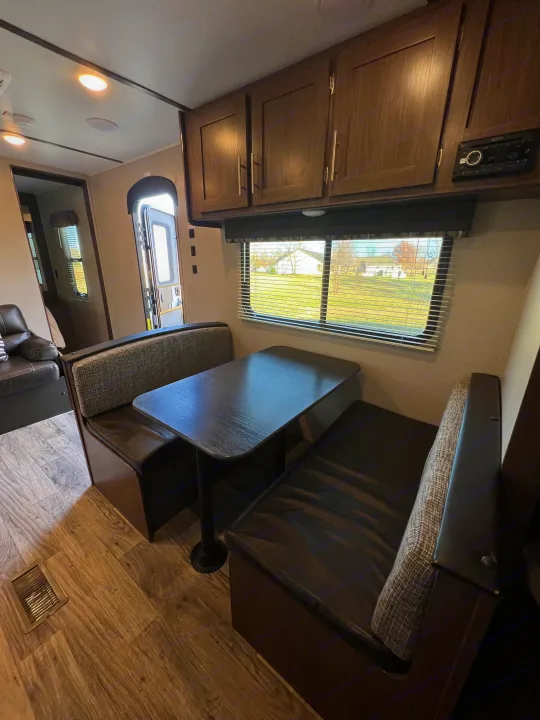 Step inside this RV rental: bright dinette, comfy bench seats, table, overhead cabinets, and a scenic window view.. Keystone RV Hideout LHS 2020