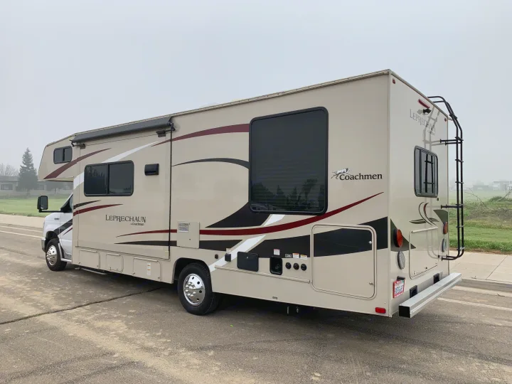 Beige Coachmen Leprechaun Class C RV rental with ladder, parked on asphalt, ideal for your next trip.. Forest River Coachmen Leprechaun 2020