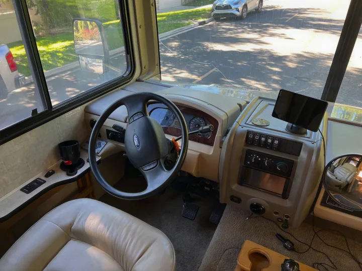 RV rental interior: driver's view of Ford cockpit with steering wheel, dashboard, and Garmin display looking out at the road.. Ford Bounder 2008