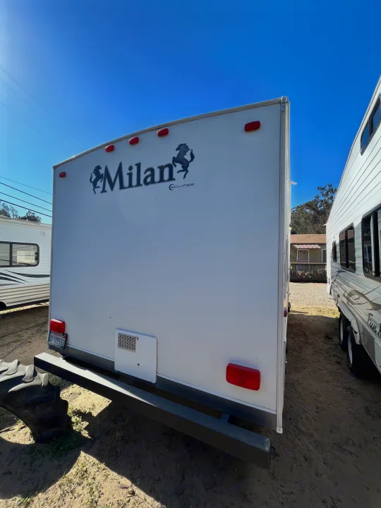 Rear view of a white Milan Eclipse RV with a horse logo, showcasing its lights & bumper. Perfect for an rv rental.. Eclipse Recreational Vehicles Milan 2011