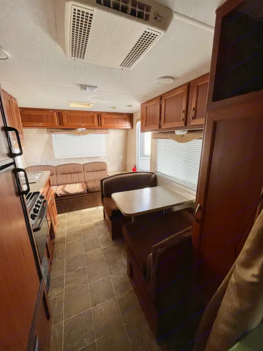 Explore this comfortable RV rental interior, featuring a full kitchen, dinette, and living area with ample storage.. Eclipse Recreational Vehicles Milan 2011