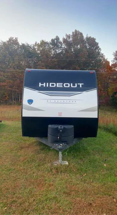 Ready for your next RV rental adventure: a black and white Hideout travel trailer parked in a grassy field.. Keystone RV Hideout 2022