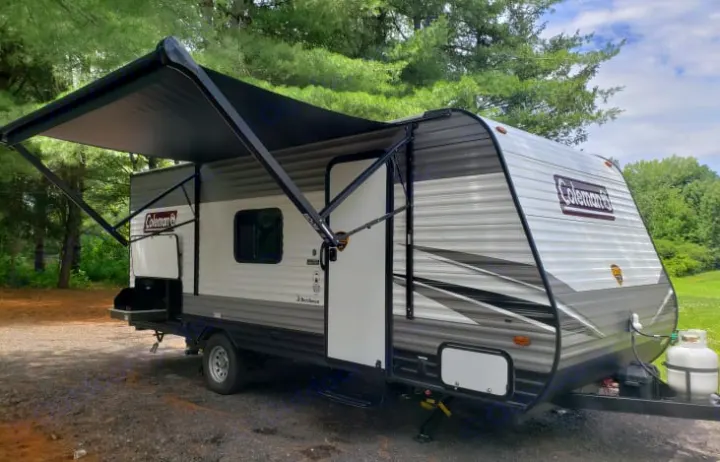 Coleman RV rental: A travel trailer with an extended awning and an outdoor kitchen setup, ready for your next adventure.. Dutchmen Coleman Lantern LT 2022