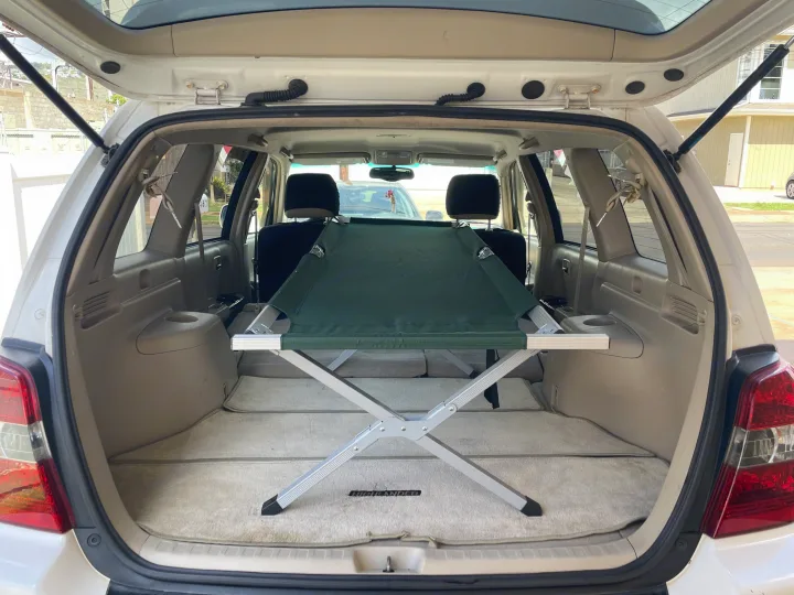 Toyota Highlander SUV cargo area ready for an adventure. A folding cot turns it into a compact RV rental option.. Toyota Highlander 2005