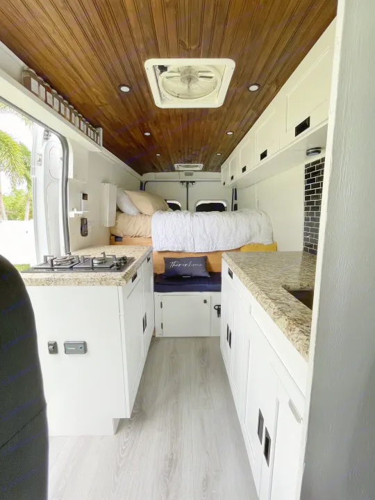 This rv rental's spacious interior features a full kitchen with granite counters, a cozy bed, and warm wood ceilings.. Other Other 2020
