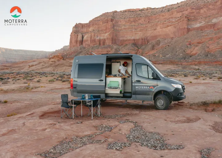 Grey Moterra rv rental campervan parked in a desert canyon. Person inside, outdoor setup. Ideal for adventure.. Mercedes-Benz Sprinter 2020