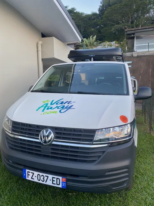 White VW camper van for RV rental, branded Van-Away.com, parked on grass. Front view with French license plate.. Volkswagen Transporter T6.1 2021