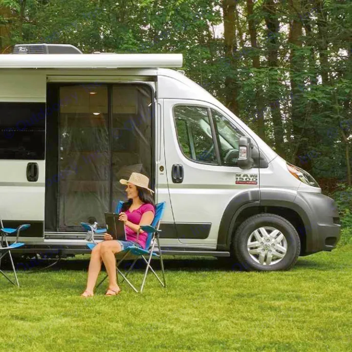 Relaxing by your RV rental. A woman in a hat enjoys the outdoors in a chair beside a white camper van with screen door.. Thor Rize 2022