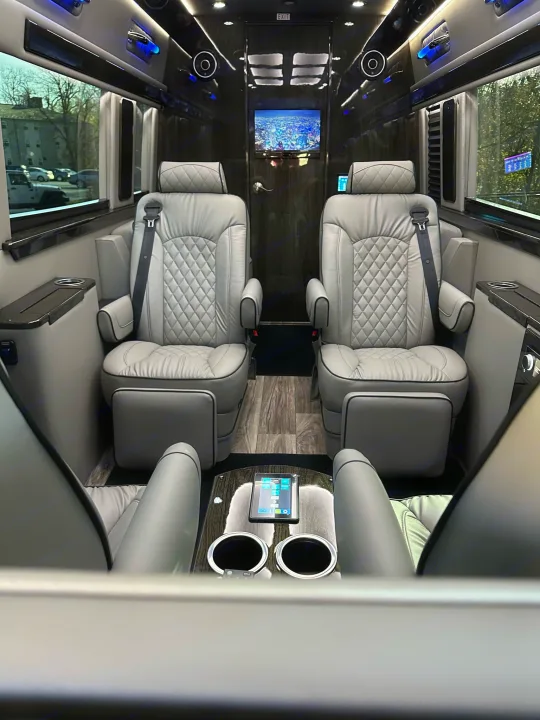 Experience premium travel in this luxury RV rental. Plush captain's chairs, media screen & ambient lighting in a custom vehicle interior.. Midwest Automotive Designs Ultimate Coach 2023