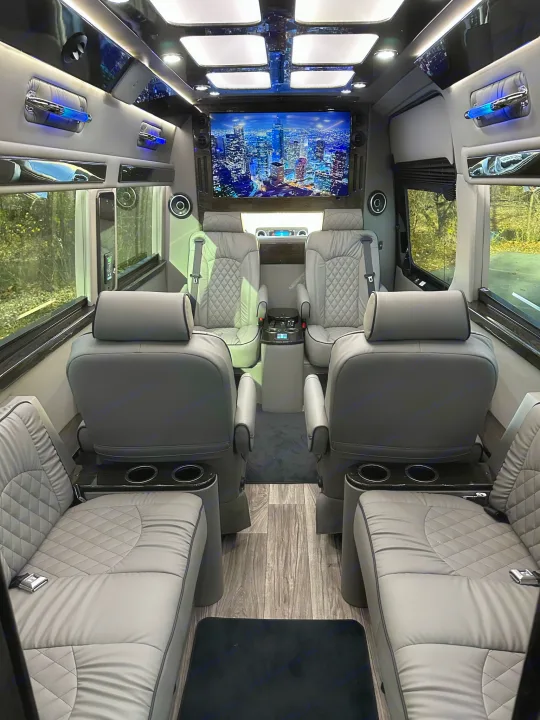 Experience this luxurious RV rental interior: spacious quilted seating, large TV, and ambient lighting.. Midwest Automotive Designs Ultimate Coach 2023