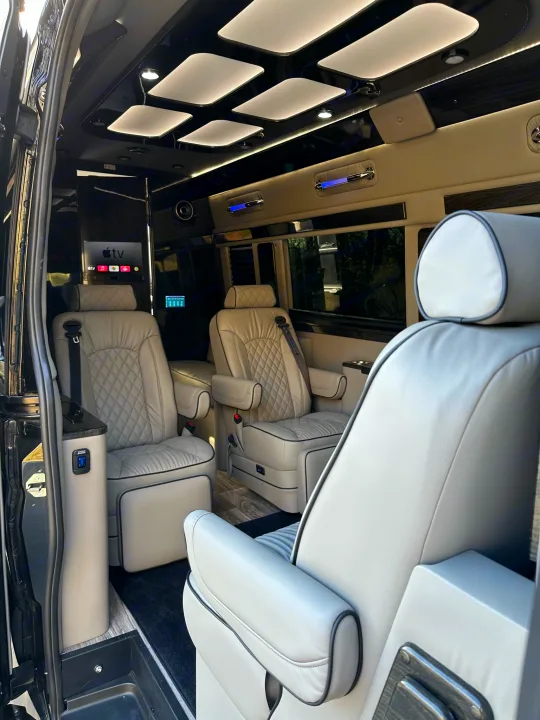 Experience luxury in this RV rental! Plush grey leather captain chairs, Apple TV, and ambient lighting in a high-end custom van.. Midwest Automotive Designs Ultimate Coach 2023