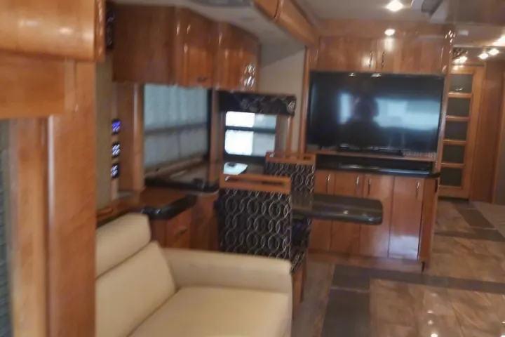 Spacious luxury RV interior with sofa, dining area, and TV. Perfect for your next rv rental adventure.. American Coach American Eagle 2017