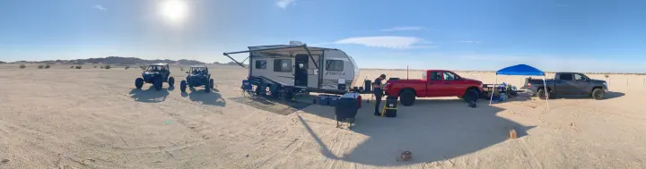 A desert campsite with an RV rental, two UTVs, and pickup trucks, for off-road adventure and outdoor living.. Genesis Supreme Rv Genesis Supreme 2022