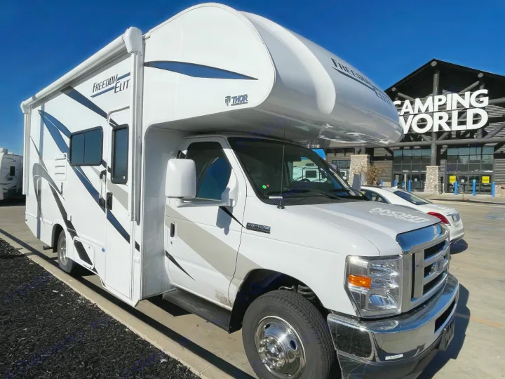 Experience adventure with an RV rental! A white Thor Freedom Elite RV parked outside a Camping World store on a sunny day.. Thor Freedom Elite 2022