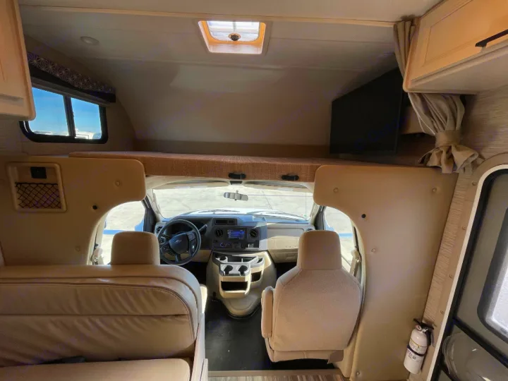 Inside this **rv rental**, discover the cockpit and a spacious cab-over bunk bed, ready for your next adventure.. Thor Freedom Elite 2022