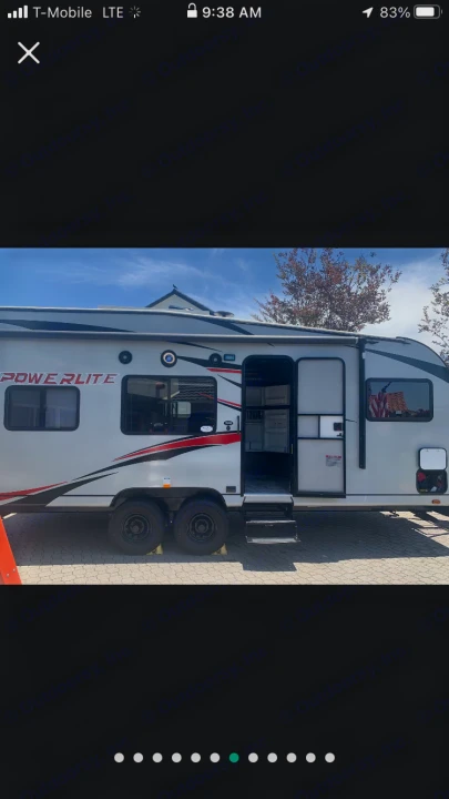 This white Powerlite travel trailer, ready for RV rental, shows its open door & steps, hinting at camping adventures.. Pacific Coachworks Powerlite 2020