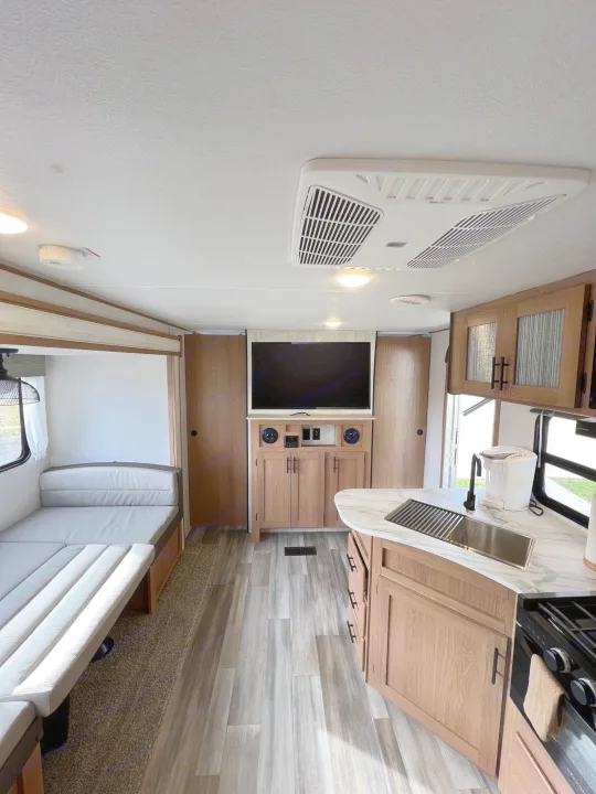 Spacious and modern RV rental interior featuring a full kitchen, entertainment center, and comfortable living area. Perfect for your next adventure!. Prime Time Avenger 2022