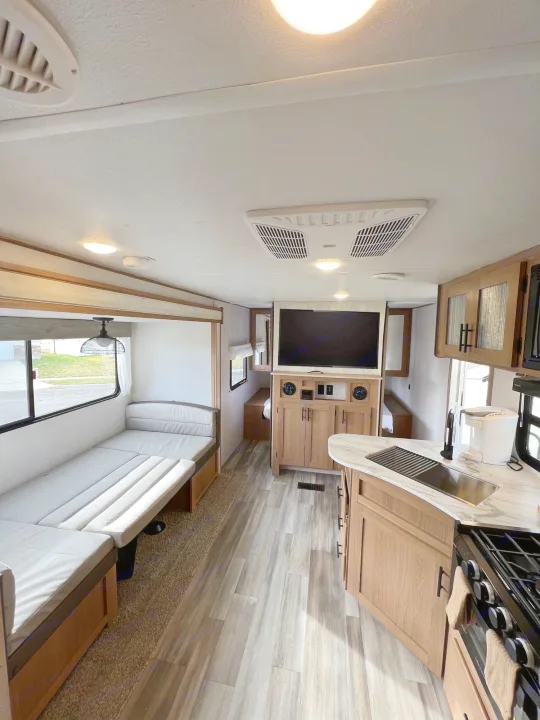 Modern RV rental interior: bright living area, fully equipped kitchen, and entertainment unit.. Prime Time Avenger 2022
