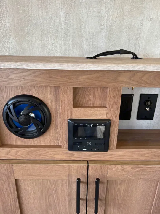 RV rental: Integrated entertainment hub with speaker, Drive stereo, and power/media outlets in wooden cabinetry.. Prime Time Avenger 2022