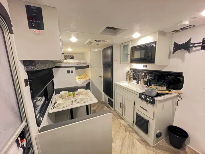 Step inside this cozy RV rental, featuring a dining area, a well-equipped kitchen, and comfortable bunk beds for your travels.. Forest River Salem FSX 2021
