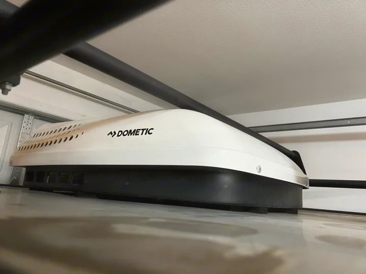 View from below of a white Dometic RV rooftop air conditioner. A vital component for comfortable RV rental travels.. Custom Camper 2021