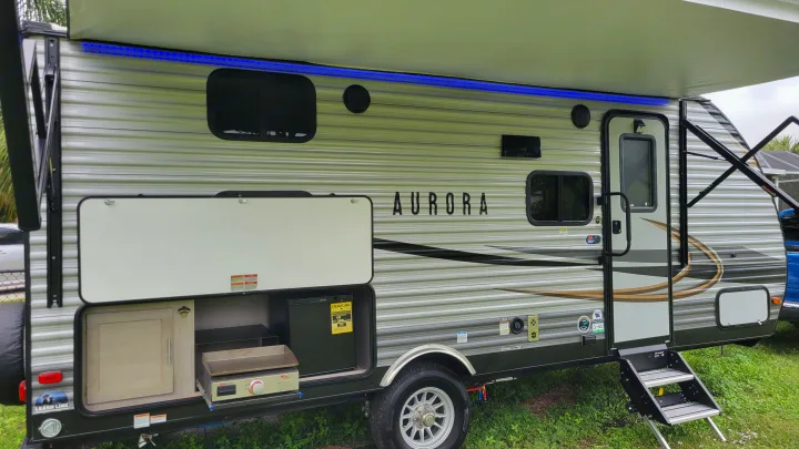 This Aurora travel trailer RV rental offers an outdoor kitchen with grill & fridge, a lighted awning, and sturdy entry steps.. Forest River Coachmen Aurora 2022