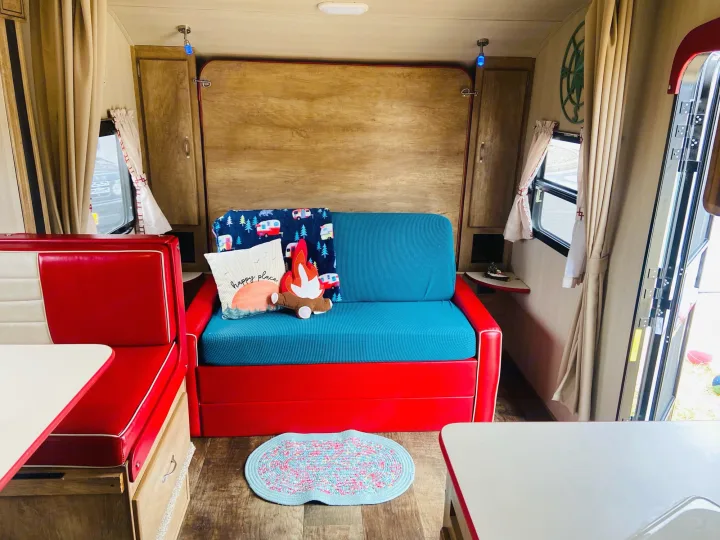 Discover this cozy rv rental interior with a bright red dinette, blue sofa, and charming camping decor.. Gulf Stream Gulfstream 2018