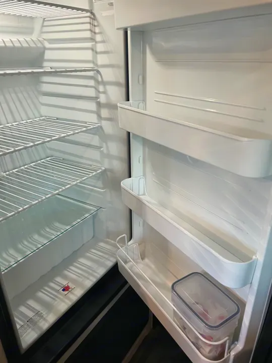 Mostly empty refrigerator interior in an RV, ready for your rv rental. Visible shelves, door storage, & one container.. Jayco Featherlight SLX8 2022