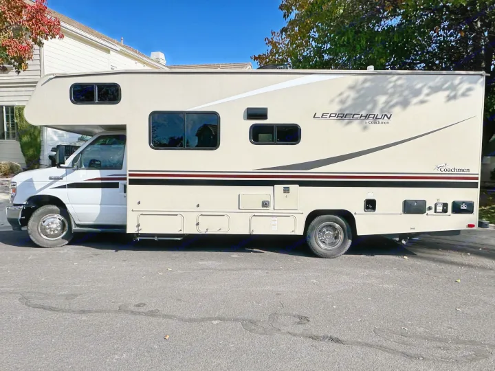 Sunny day view of a beige Coachmen Leprechaun RV rental, a Class C motorhome ideal for family road trips and camping.. Coachmen Leprechaun 2022