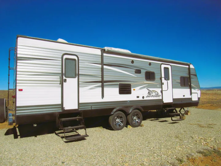 This Jay Flight travel trailer RV rental, parked on a gravel lot under a clear blue sky, is ready for your next adventure.. Jayco Jay Flight 2016
