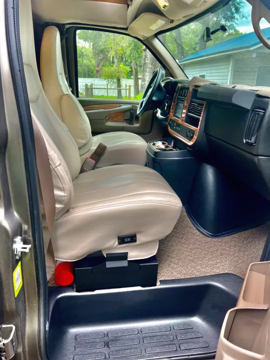 This RV rental's inviting front cabin has cream leather seats, a wood-trimmed dash, and safety essentials like a fire extinguisher.. Roadtrek Roadtrek Class B 2015