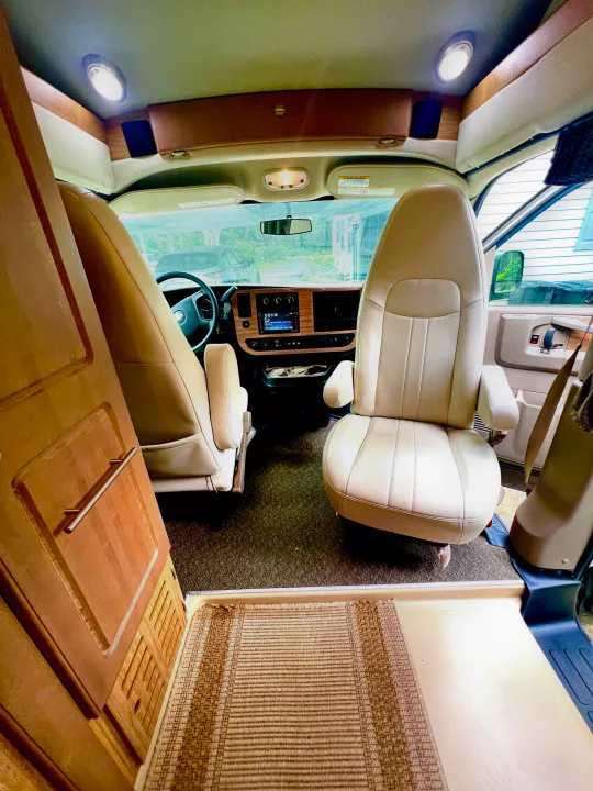 Bright interior of an **rv rental**, featuring comfortable front seats, dashboard, and driving area. Ideal for road trips.. Roadtrek Roadtrek Class B 2015