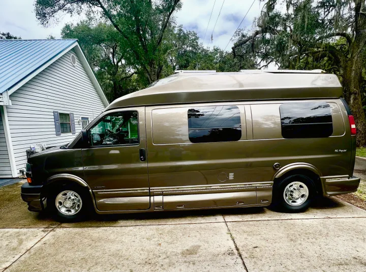 Roadtrek 190 Popular RV rental. This high-top conversion van, parked on concrete near a house & mossy trees, awaits.. Roadtrek Roadtrek Class B 2015