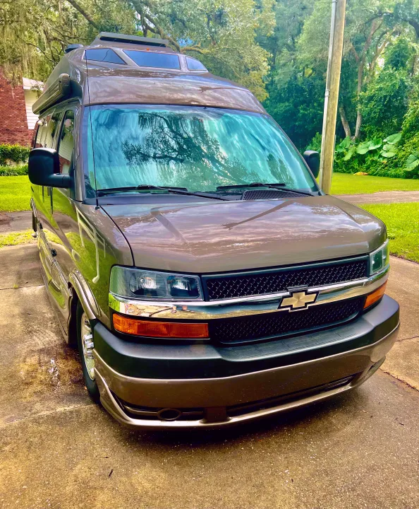 Front view of a brown RV rental van parked on a driveway, ideal for camping and road trips.. Roadtrek Roadtrek Class B 2015