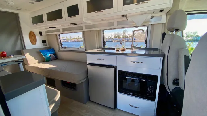 Enjoy this modern RV rental interior, featuring a full kitchen, comfortable seating, and scenic waterfront views.. Coachmen Nova20 Li3.  Lithium / generator free silent power 2022