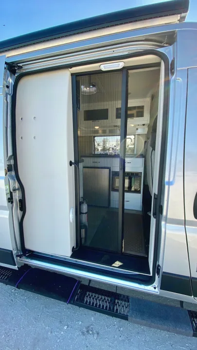 Step inside this RV rental! Open van door shows a compact kitchen, screen door, and entry steps.. Coachmen Nova20 Li3.  Lithium / generator free silent power 2022