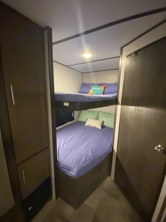Cozy RV rental bedroom featuring a comfy lower bed and an upper bunk, ideal for family trips.. Keystone RV CMMM262BH21 2021