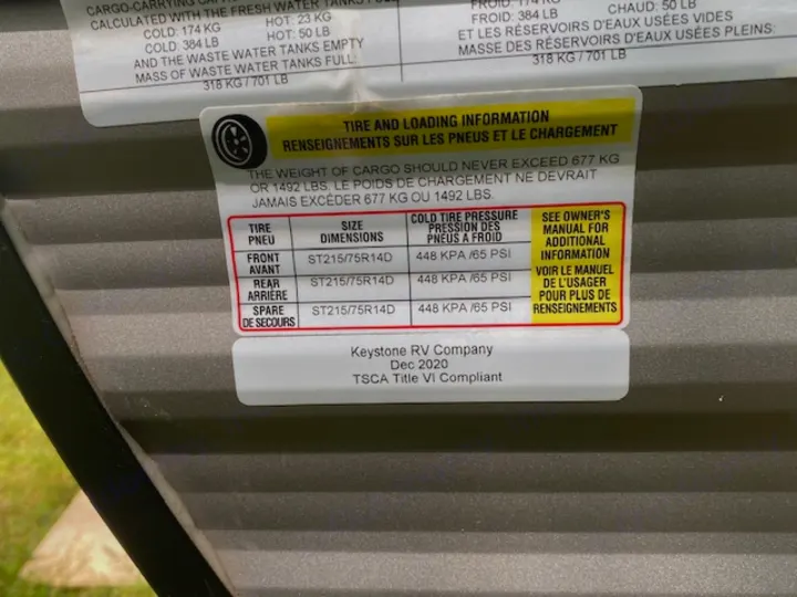 RV rental safety label with tire pressure (65 PSI) and cargo weight (1492 LBS) information.. Keystone RV CMMM262BH21 2021