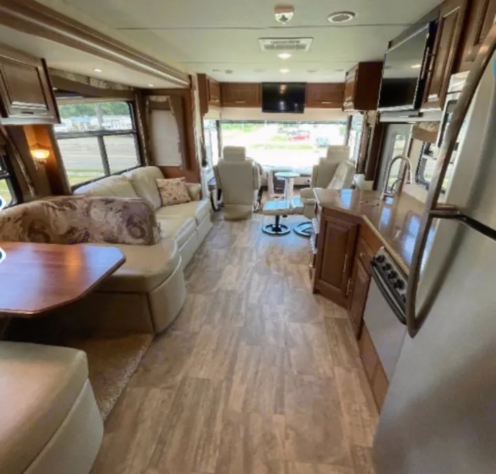 Explore this spacious RV rental's modern interior: comfy living area, full kitchen, and front cockpit seats visible.. Georgetown XL 2015