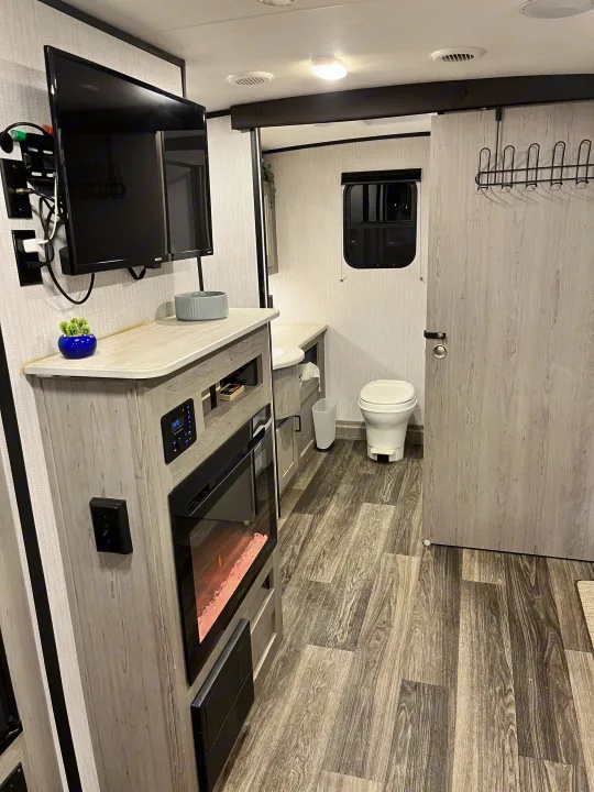 RV rental interior with TV, fireplace, and compact bathroom setup.. Heartland RVs Mallard 2021