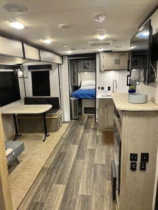 Modern rv rental interior showcasing a dining area, kitchen, and cozy bedroom, perfect for your next adventure.. Heartland RVs Mallard 2021