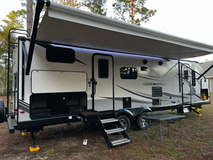 Explore nature with this White Hawk RV rental, featuring an extended awning, outdoor kitchen, and accessible steps.. Jayco White Hawk 2022