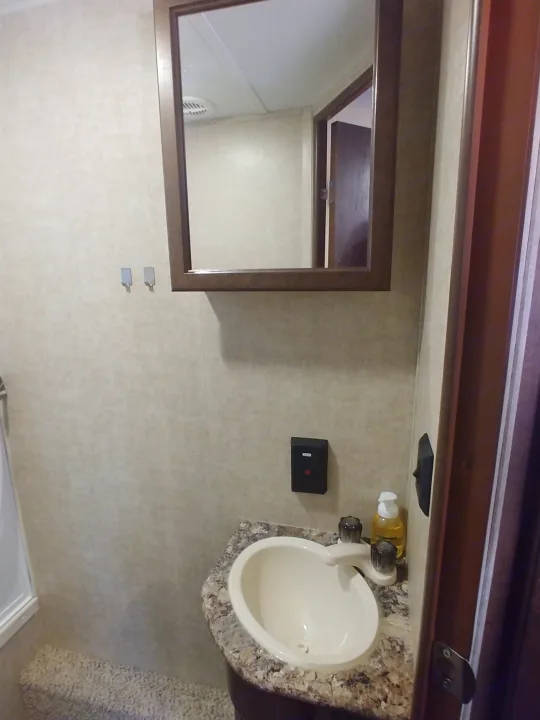 Inside an RV rental: a clean bathroom featuring a sink, mirror, and shower area.. Keystone RV Hideout LHS 2017